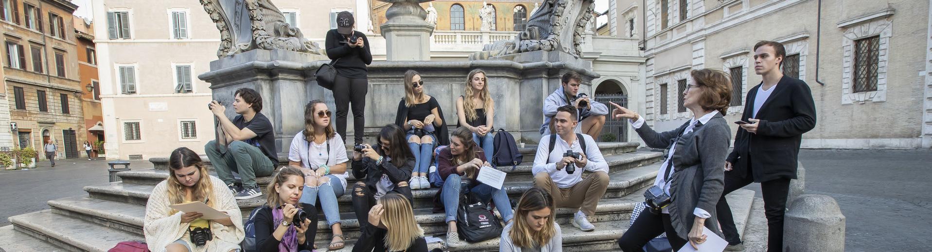 一群威尼斯人赌场网站学生聚集在意大利罗马的一个喷泉前.